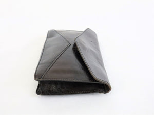 Tummanruskea kädessä kannettava kirjekuorimallinen laukku